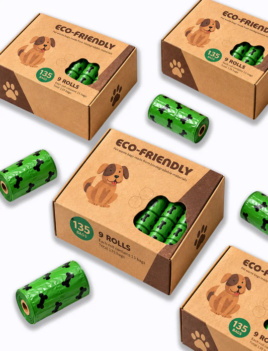 Three brown cardboard boxes of Eco-Friendly dog poop bags are arranged on a white background, with several green rolls of the bags scattered around them. The boxes feature a brown dog illustration and a green circular badge indicating 135 bags.