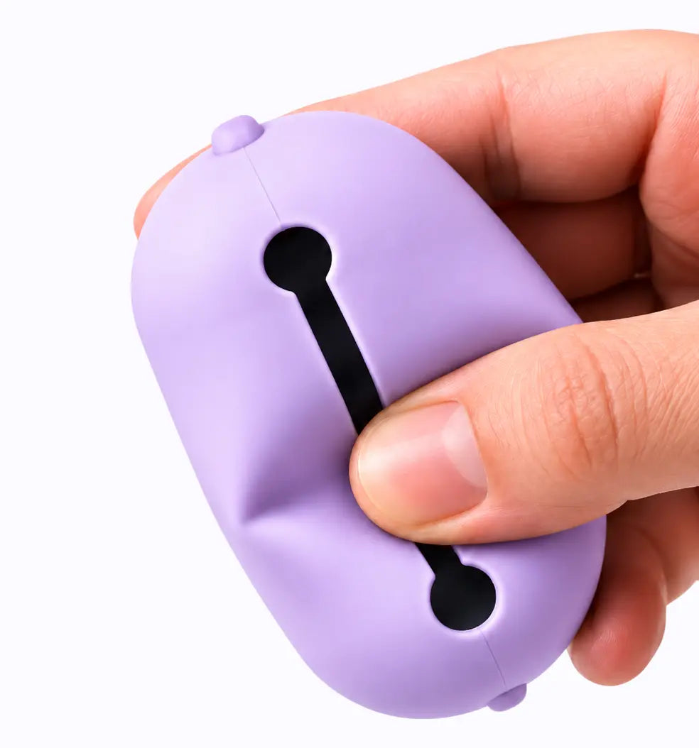lilac LuxryPaw silicone pet waste bag holder being held in a hand showing its flexible material and dispensing slot