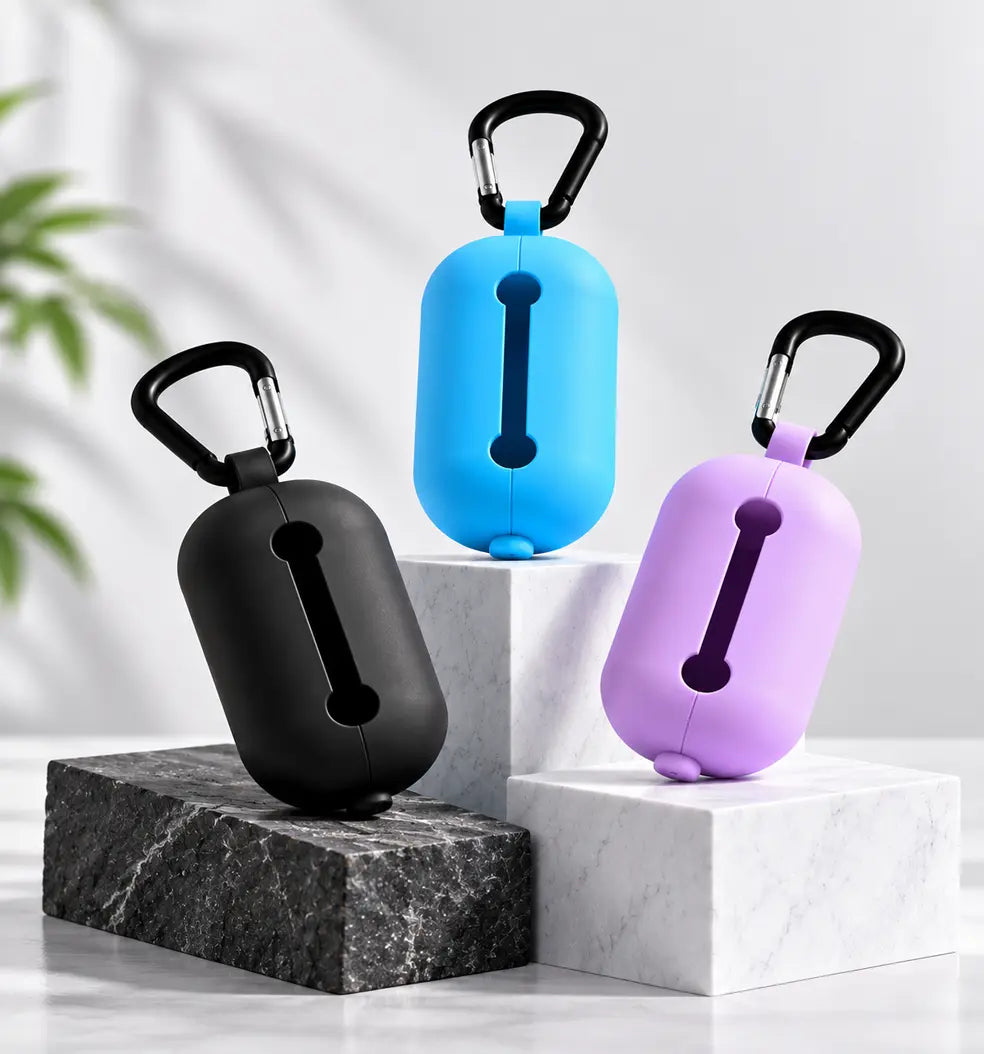 lilac LuxryPaw silicone pet waste bag holders in blue, black, and lilac with metal carabiners on marble display blocks