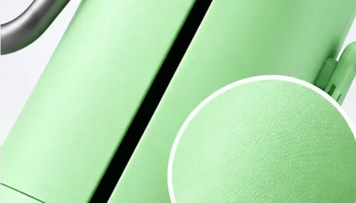 Close-up detail shot of a light green product, showing a circular inset of the textured surface and part of a dark metallic component against a white background.